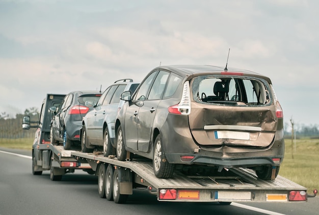 Laweta z rozbitym samochodem na drodze kraju Laweta transportu samochodu na autostradzie Koncepcja transportu usług samochodów