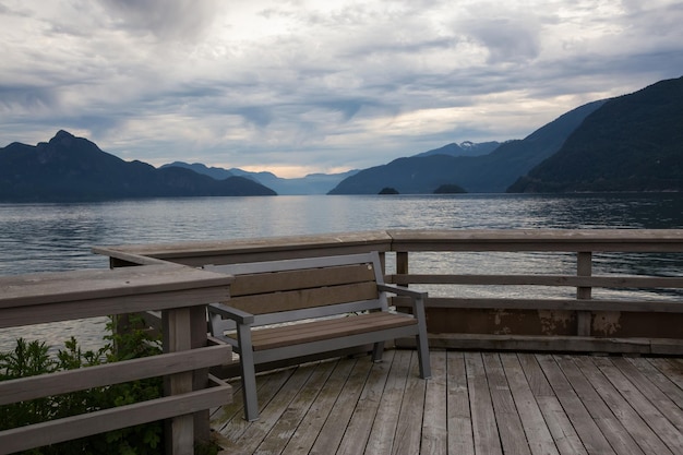 Ławka na drewnianym pokładzie z widokiem na Howe Sound z górami