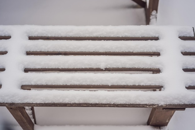 Ławki w zimowym parku miejskim, który został wypełniony śniegiem