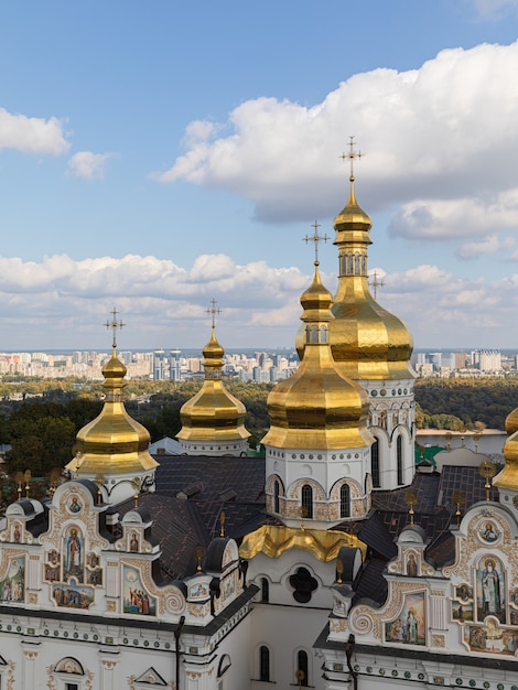 Ławra Peczerska w Kijowie. Katedra Zaśnięcia Najświętszej Maryi Panny. Kijów. Ukraina. Zielone i żółte jesienne drzewa na tle. Dniepr i panorama Kijowa w tle