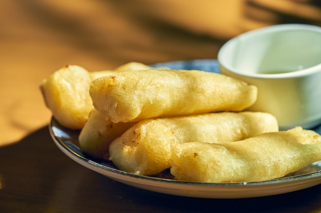 Leche frita czyli smażone mleko na białym talerzu ze słodkim sosem. kuchnia hiszpańska