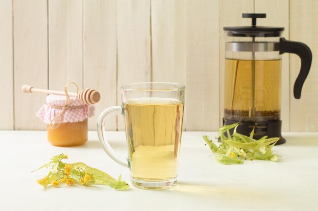Lecznicza herbata lipowa i miód Filiżanka herbaty ziołowej z kwiatami lipy na drewnianym tle Kopiuj przestrzeń