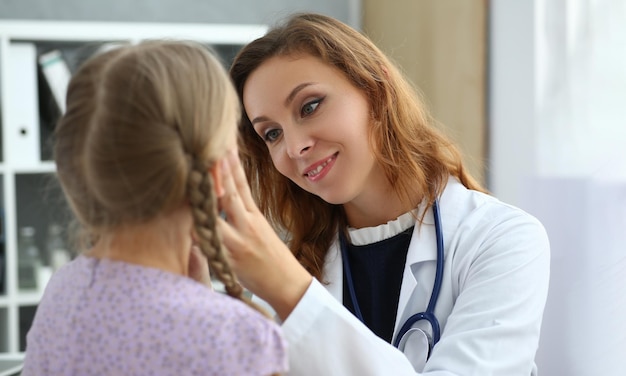 Lekarka sprawdza gardło małej dziewczynki w gabinecie lekarskim