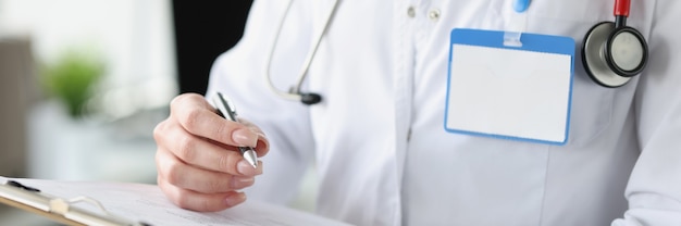 Lekarka trzyma schowek z dokumentami i długopisem w dłoniach zbliżenie