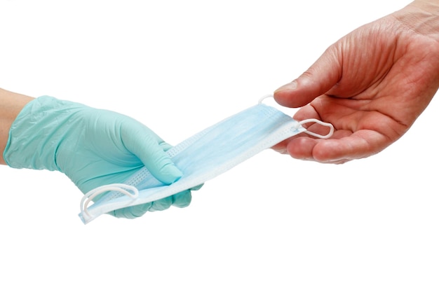 Lekarka w lateksowej rękawiczce daje pacjentowi medyczną maskę ochronną