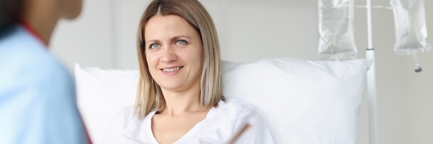 Lekarz bada kobietę leżącą na łóżku w koncepcji terapii infuzyjnej szpitala hospital