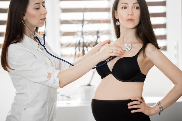 Lekarz bada kobietę w ciąży