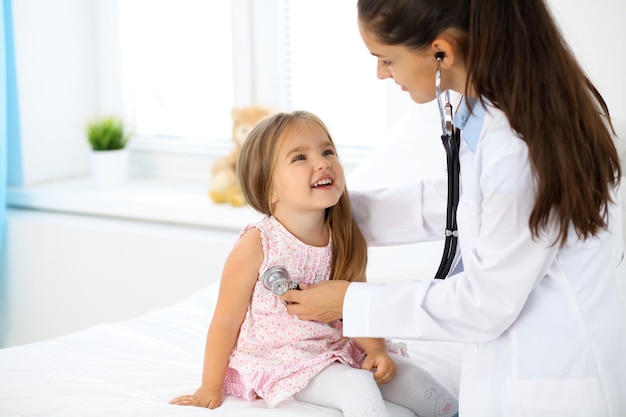 Zdjęcie lekarz bada małą dziewczynkę stetoskopem.
