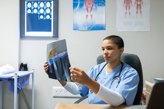 Zdjęcie lekarz bada raport rentgenowski przy biurku w szpitalu