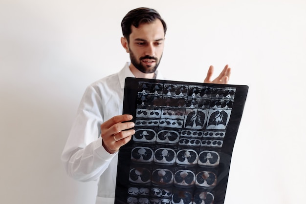 Lekarz bada zdjęcie rentgenowskie na białym tle