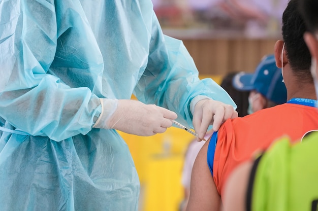 Lekarz daje strzał zastrzyk szczepionki ramię pacjenta. Profilaktyka szczepień wirus covid19 pandemia