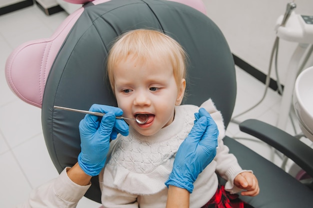 Zdjęcie lekarz dentysta bada zęby dziecka na fotelu dentystycznym. koncepcja medycyny i stomatologii.