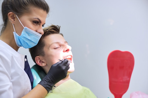 Lekarz dentysta leczy zęby nastoletniego chłopca