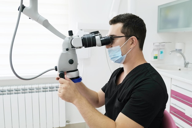 Lekarz dentysta przeprowadza kontrolę badawczą sprzętu mikroskopowego