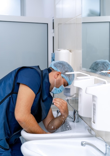 Zdjęcie lekarz dezynfekuje ręce. specjalista medyczny myje ręce przed operacją. chirurgia.