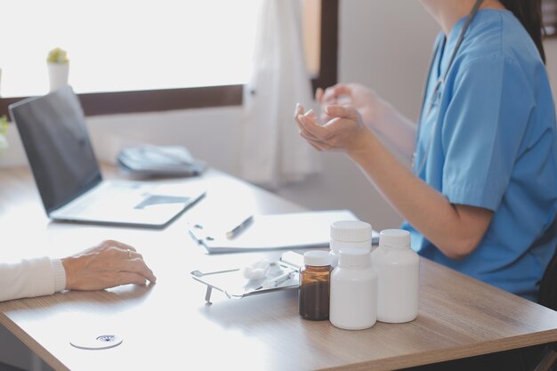 Lekarz i pacjent rozmawiają siedząc przy biurku w biurze szpitala zbliżenie ludzkich rąk Medycyna i koncepcja opieki zdrowotnej