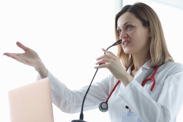 Lekarz kobieta mówi do mikrofonu podczas prezentacji