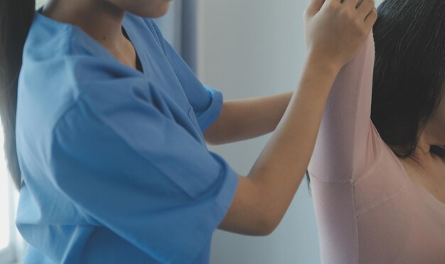 Zdjęcie lekarz lub fizjoterapeuta bada ból pleców i okolice kręgosłupa, aby udzielić porady w ośrodku rehabilitacji