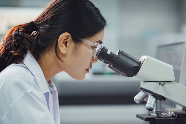 Lekarz lub naukowiec pracujący w laboratorium Wykrycie wirusa lub bakterii w próbkach za pomocą mikroskopu