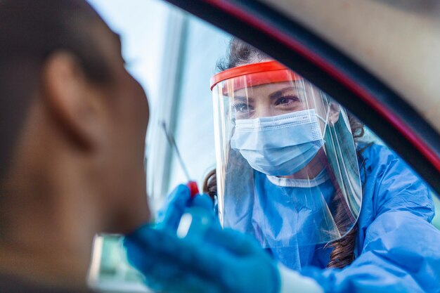 Lekarz Lub Pielęgniarka Noszący Maskę Ppe N95 I Osobistą Fartuch Ochronny Stojący Obok Drogi Przesiewowej Na Obecność Wirusa Covid19 Test Wymazu Z Nosa