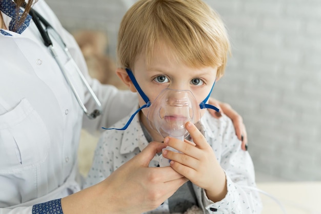 Lekarz medycyny stosujący lek wziewny u małego chłopca z inhalacyjną terapią astmy