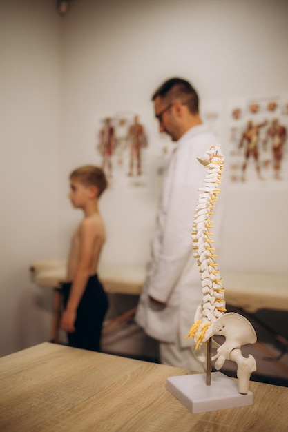 Zdjęcie lekarz neurolog pediatryczny bada plecy pięcioletniego chłopca, który ma bóle pleców leczenie bólu mięśni i skoliozy u dzieci