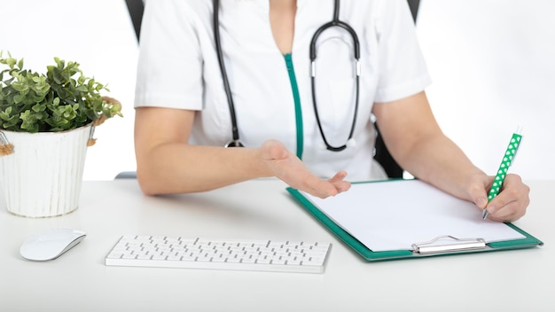 Zdjęcie lekarz, pielęgniarka przy biurku z dokumentami na stole z białym tłem.