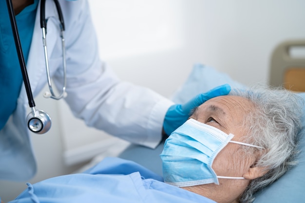 Lekarz Pomaga Azjatyckiej Starszej Kobiecie Noszącej Maskę W Szpitalu W Celu Ochrony Przed Koronawirusem