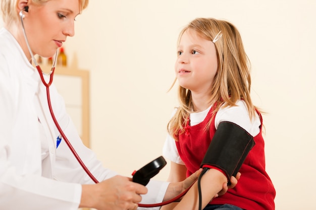 Lekarz pomiaru ciśnienia krwi dziecka