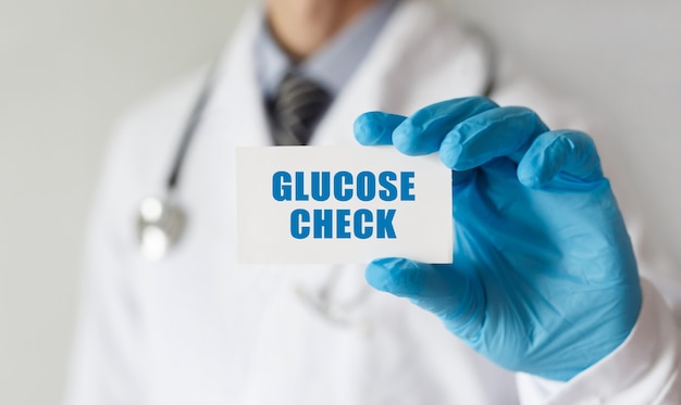 Lekarz posiadający kartę z tekstem Sprawdź poziom glukozy, pojęcie medyczne
