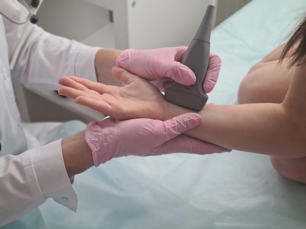 Lekarz przeprowadza badanie ultrasonograficzne nadgarstka dziecka pacjenta