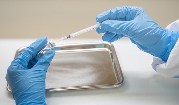 Zdjęcie lekarz przygotowuje zastrzyk szczepionkowy stymulujący odporność pacjenta.