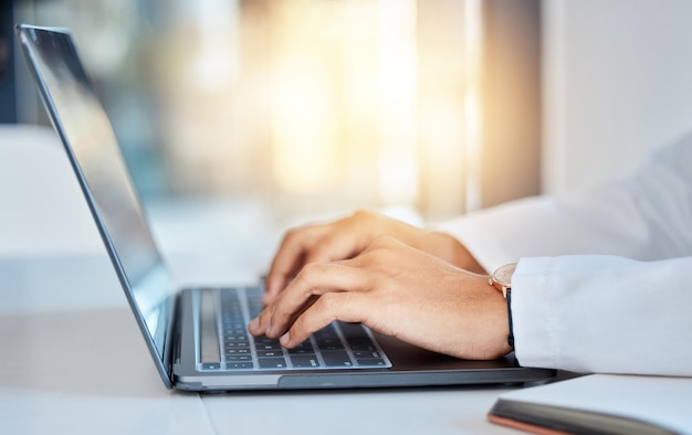 Lekarz ręce pisząc na laptopie, robiąc badania medyczne przy szpitalnym stole i czytając e-maile online w pracy Specjalista ds. opieki zdrowotnej lub pracownik medyczny za pomocą klawiatury i konsultując się przez Internet