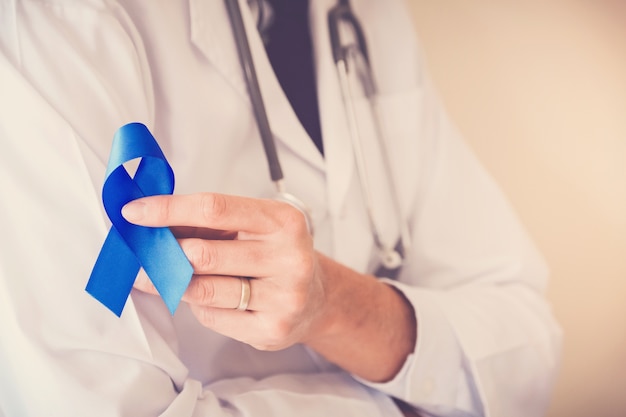 Lekarz ręce trzymając niebieską wstążką, cukrzyca i Colorectal Cancer Awareness