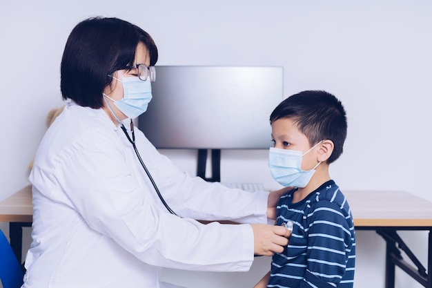 Lekarz siedzi w pracy badając dziecko pacjenta