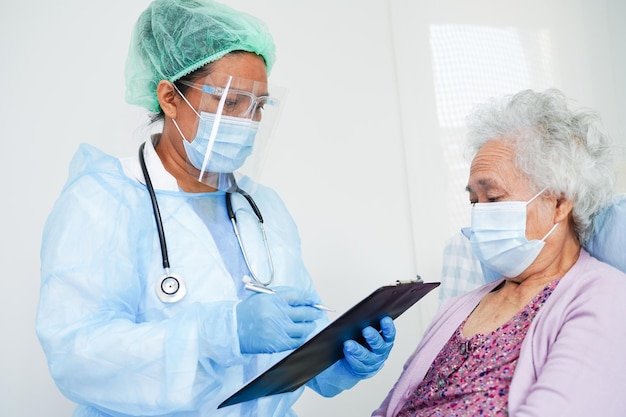 Lekarz sprawdza Azjatycka starsza starsza kobieta pacjentka nosząca maskę chroniącą przed koronawirusem Covid