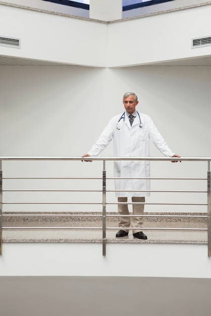 Lekarz stoi przy balustradzie korytarza