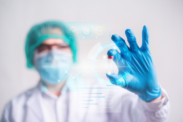 Zdjęcie lekarz trzymając butelkę szczepionki z nowoczesnym ekranem interfejsu hud na tle szpitala, innowacji i technologii medycznych.