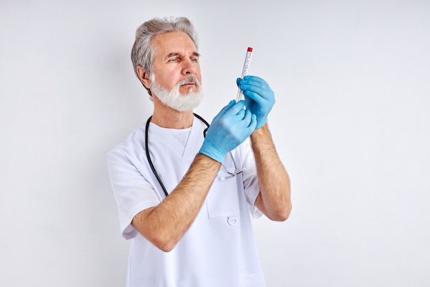 Lekarz trzymając probówkę z płynnym roztworem w laboratorium