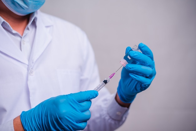 Zdjęcie lekarz trzymając rurkę ze szczepionką koronawirusową i strzykawką. koncepcja opieki zdrowotnej i medycznej.
