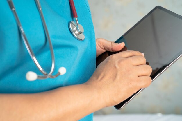 Lekarz trzymający cyfrowy tablet do wyszukiwania danych w celu leczenia pacjenta na oddziale szpitala pielęgniarskiego zdrowy silna koncepcja medyczna