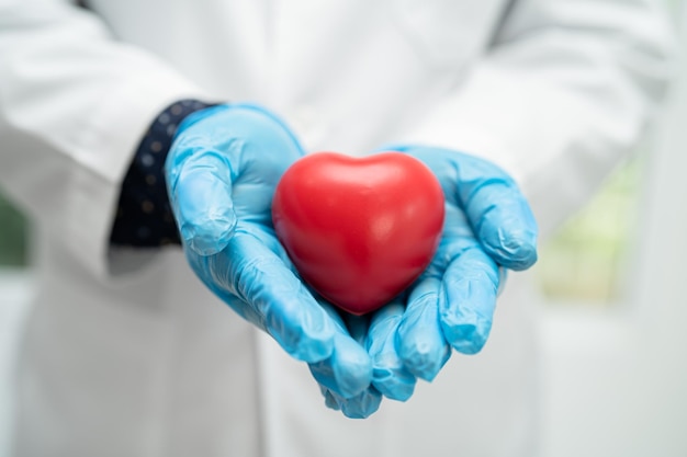 Lekarz trzymający czerwone serce na oddziale szpitalnym zdrowa, silna koncepcja medyczna