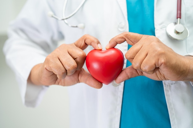 Lekarz trzymający czerwone serce na oddziale szpitalnym zdrowa silna koncepcja medyczna