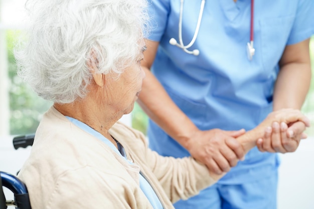 Lekarz trzymający się za ręce Azjatycka starsza kobieta pomoc i opieka nad pacjentem w szpitalu