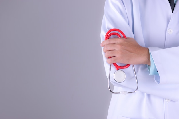 Lekarz w białym mundurze suknia z stetoskop w szpitalu na tle białej ściany