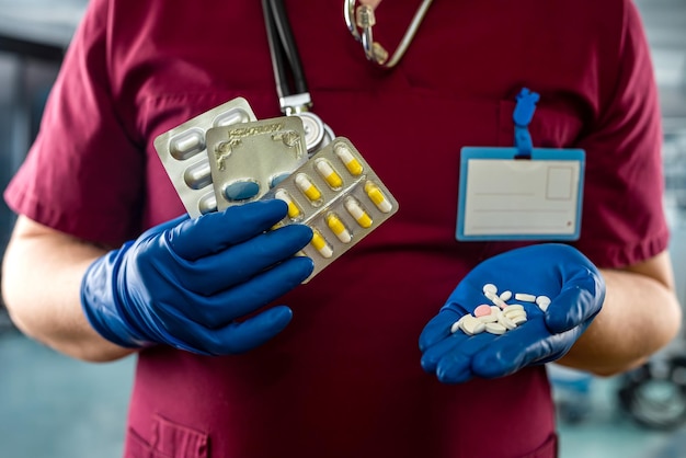 Lekarz w czerwonym mundurze trzymający leki w szpitalnej koncepcji tabletek generycznych