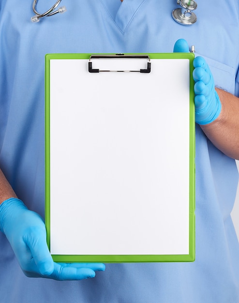 Zdjęcie lekarz w niebieskim mundurze i lateksowych rękawiczkach trzyma niebieski uchwyt na kartki papieru