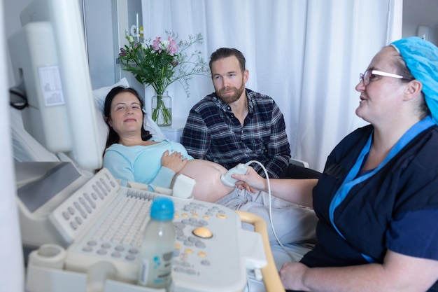 Lekarz wykonuje ultradźwiękowe badanie dla kobiety w ciąży w szpitalu