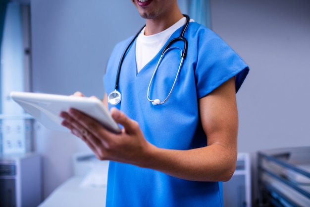 Lekarz za pomocą cyfrowego tabletu na oddziale w szpitalu