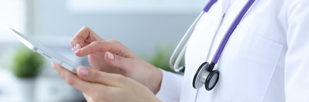 Lekarz ze stetoskopem działa na cyfrowym tablecie zbliżenie koncepcji konsultacji online